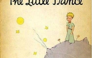 Vintage-style illustration from The Little Prince, showing the small blue-gray planet with the prince standing on it, yellow stars and suns, and the title text at the top on a warm cream background.